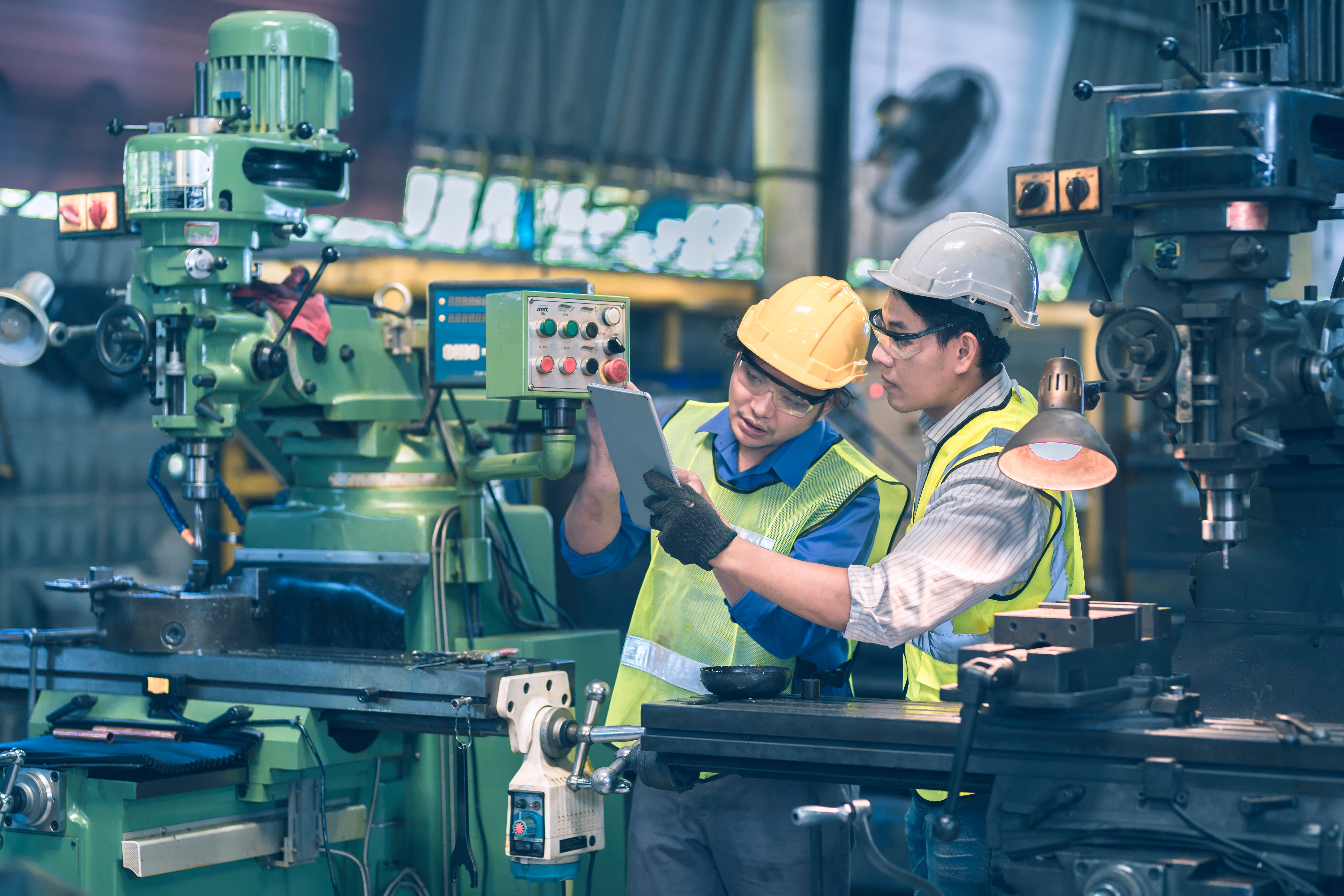 Production floor operators looking at a tablet